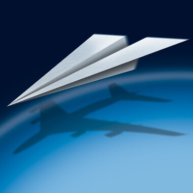 paper airplane throwing the shadow of a real airplane